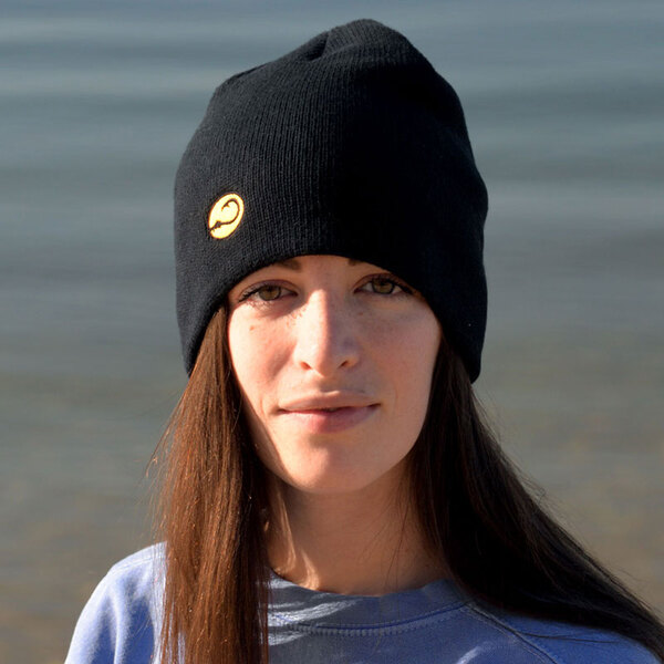 young woman in Hook Life watch cap on the beach